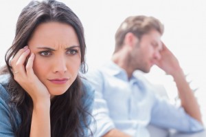 Stressed woman holding her head next to her partner