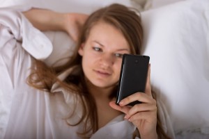 woman_looking_at_cellphone_bed