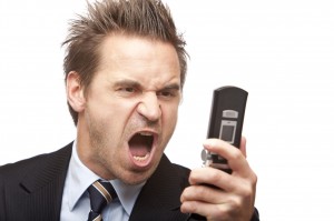 Businessman has stress and sreams into mobile phone
