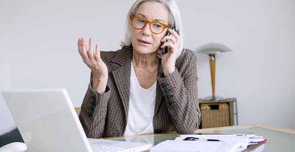 tax-blog-mature-woman-sitting-at-a-desk-on-the-phone