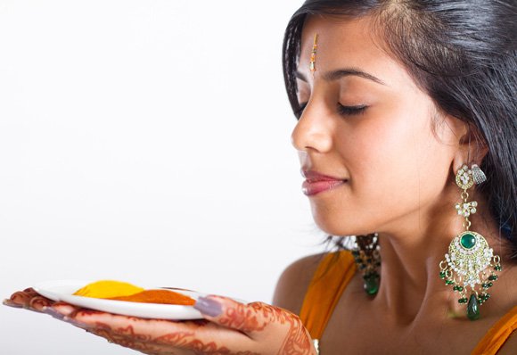 young-indian-woman-holding-a-plate-with-turmeric